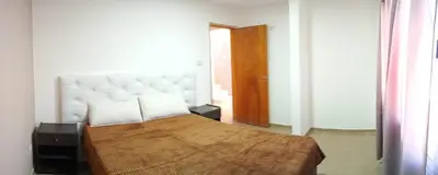 a bedroom with a large bed with a white headboard at Casa de vacaciones in Villa Carlos Paz
