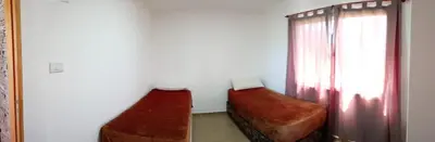 two ottomans in a room with a window at Casa de vacaciones in Villa Carlos Paz