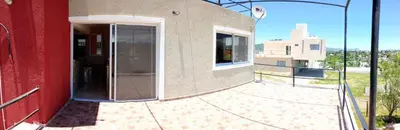 a red building with a revolving door on a balcony at Casa de vacaciones in Villa Carlos Paz