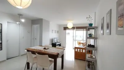 a dining room with a wooden table and white chairs at Santa Fe 49 in Cordoba