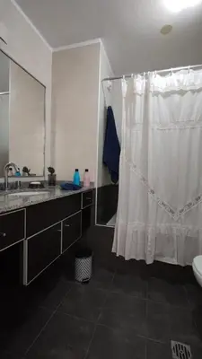 a bathroom with a shower curtain and a sink at Santa Fe 49 in Cordoba