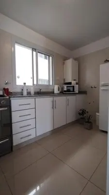 a kitchen with white cabinets and a white refrigerator at Santa Fe 49 in Cordoba