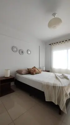 a white bedroom with a bed and a window at Santa Fe 49 in Cordoba