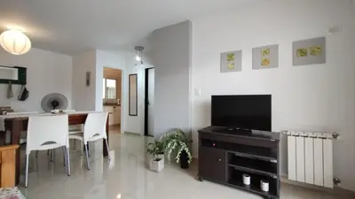 a living room with a television and a table and chairs at Santa Fe 49 in Cordoba