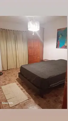 a bedroom with a bed and a chandelier at Mifauna in Villa del Dique