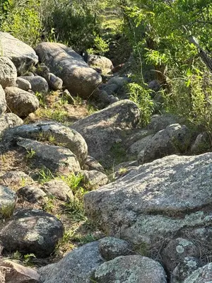a bunch of rocks on a hill with grass at El Ashva casa de campo y santuario de caballos in Las Calles