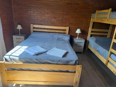 a bedroom with two bunk beds and a brick wall at Cabañas AdamiS in Villa Cura Brochero
