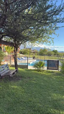 a park with a tree and a swimming pool at Cabañas AdamiS in Villa Cura Brochero
