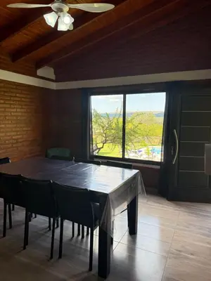 a ping pong table in a room with a large window at Cabañas AdamiS in Villa Cura Brochero
