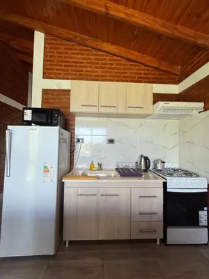 a kitchen with a white refrigerator and a sink at Cabañas AdamiS in Villa Cura Brochero