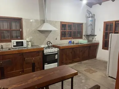 a kitchen with wooden cabinets and a stove top oven at Casona Las Calles in Las Rabonas