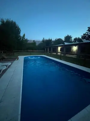 a swimming pool with blue water at night at Casona Las Calles in Las Rabonas