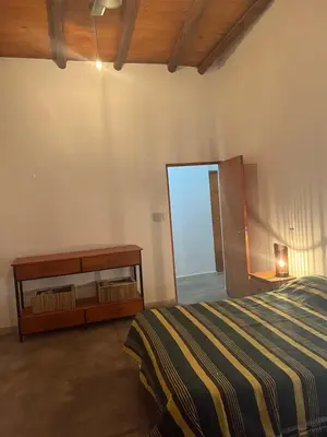 a bedroom with a bed and a table and a window at Casona Las Calles in Las Rabonas