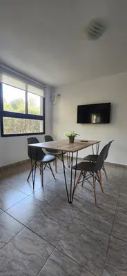 a dining room with a wooden table and chairs at Alojamiento en las sierras 2 dormitorios in Villa General Belgrano