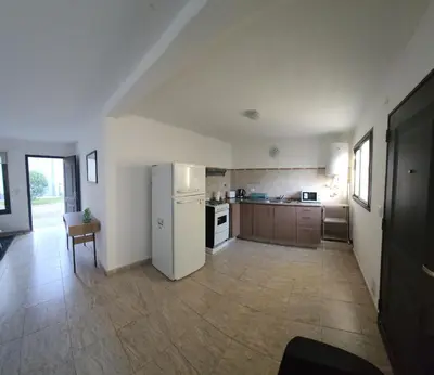 a kitchen with a white refrigerator and a table at Alojamiento en las sierras 2 dormitorios in Villa General Belgrano