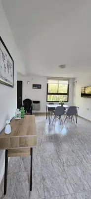 a living room with a table and chairs at Alojamiento en las sierras 2 dormitorios in Villa General Belgrano
