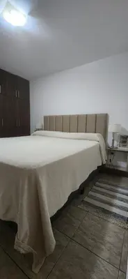 a bedroom with a large bed with a blanket on it at Alojamiento en las sierras 2 dormitorios in Villa General Belgrano
