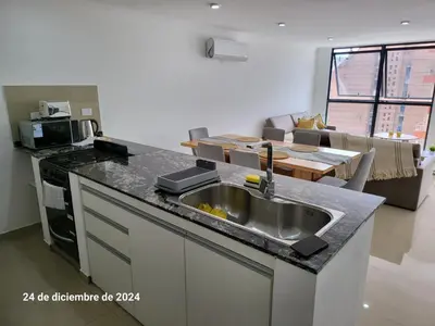 a kitchen with a sink and a living room at plaza Colonn in Cordoba