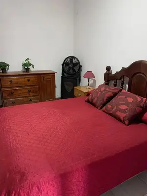 a bedroom with a bed with a red comforter at Alta vista casa de campo Tanti in Tanti