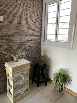 a room with a brick wall and a table with plants at Alta vista casa de campo Tanti in Tanti