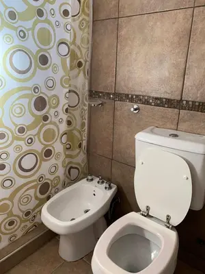a bathroom with a toilet and a shower curtain at Alta vista casa de campo Tanti in Tanti