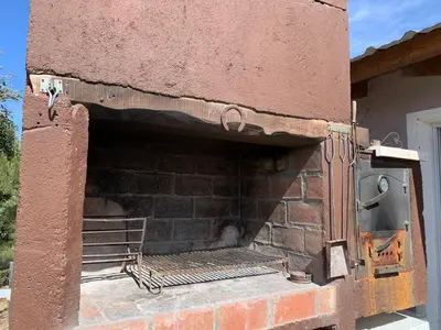 an outdoor brick fireplace with a chair in it at Alta vista casa de campo Tanti in Tanti