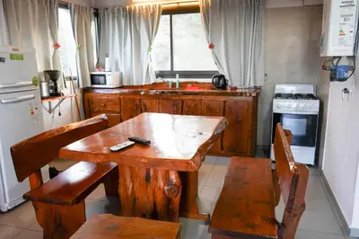 a kitchen with a wooden table and chairs in it at Refugio Alpino in La Cumbrecita