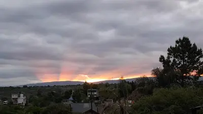 a rainbow in the sky over a city at Cabañas Vista Ensueño in La Estancia