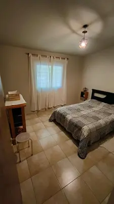 a bedroom with a bed and a table and a window at Apartamento Urbano Bialet Masse in Bialet Massé