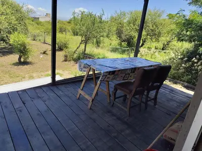 a table and two chairs on a deck with a view at La soñada in Villa Santa Cruz del Lago