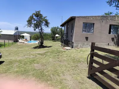 a building with a fence in front of a yard at La soñada in Villa Santa Cruz del Lago