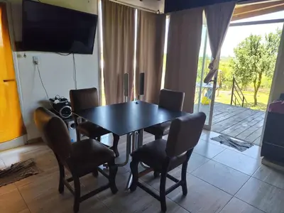 a dining room with a table and chairs and a television at La soñada in Villa Santa Cruz del Lago