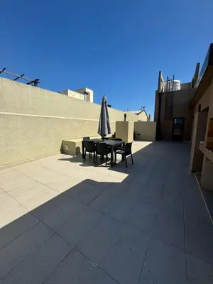 a patio with an umbrella and a table and chairs at Departamento Tatin in Villa Carlos Paz