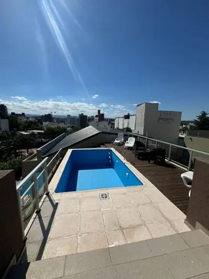a swimming pool on the roof of a building at Departamento Tatin in Villa Carlos Paz