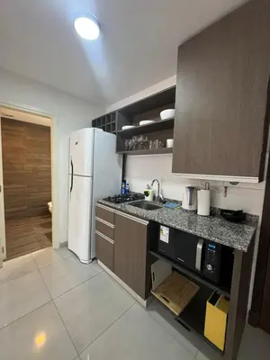 a kitchen with a white refrigerator and a sink at Departamento Tatin in Villa Carlos Paz