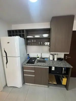 a small kitchen with a refrigerator and a sink at Departamento Tatin in Villa Carlos Paz