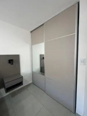 a bathroom with a sliding glass door with a sink at Departamento Tatin in Villa Carlos Paz