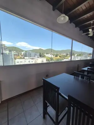 a dining room with a table and chairs and a large window at Departamento Claudio in Villa Carlos Paz