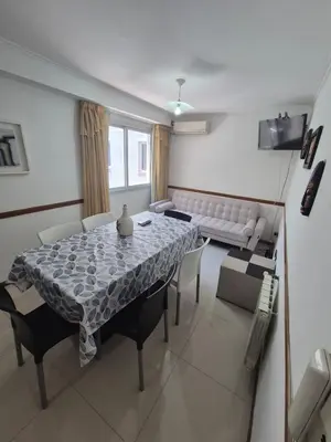 a dining room with a table and chairs and a couch at Departamento Claudio in Villa Carlos Paz