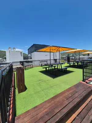 a group of picnic tables with umbrellas on a deck at Departamento Claudio in Villa Carlos Paz
