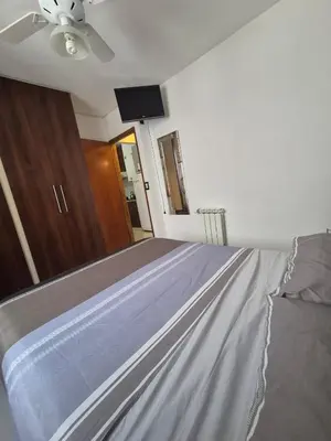 a bedroom with a bed with a ceiling fan at Departamento Claudio in Villa Carlos Paz