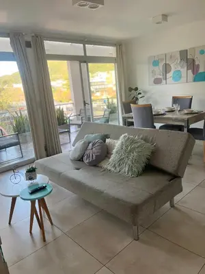 a living room with a couch with pillows on it at Departamento céntrico Terraza propia con vista a las montañas in Villa Carlos Paz
