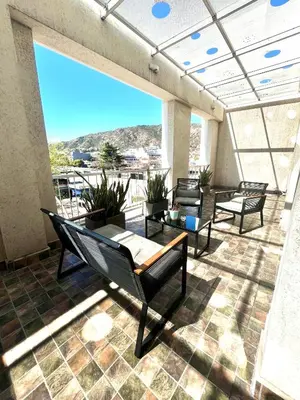 a balcony with chairs and tables and a view at Departamento céntrico Terraza propia con vista a las montañas in Villa Carlos Paz