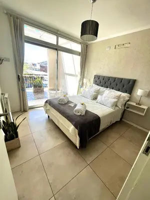 a bedroom with a large bed and a large window at Departamento céntrico Terraza propia con vista a las montañas in Villa Carlos Paz