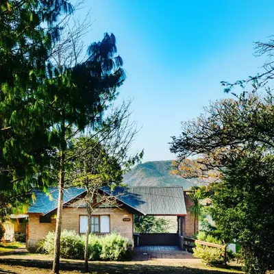 a house with a mountain in the background at Complejo Falda del Sauce in Villa General Belgrano