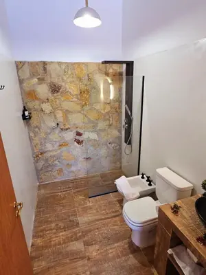 a bathroom with a toilet and a shower in it at Complejo Falda del Sauce in Villa General Belgrano