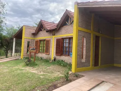 a small house with a sign in front of it at Cabañas Onirico in Mina Clavero