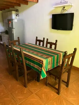 a dining room table with a colorful table cloth on it at Cabañas Onirico in Mina Clavero