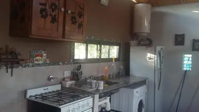 a kitchen with a stove and a refrigerator at Frente a la sierra in Quebrada de los Pozos