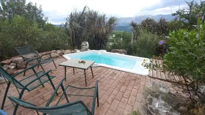 a pool with chairs and a table and a table and chairs at Frente a la sierra in Quebrada de los Pozos